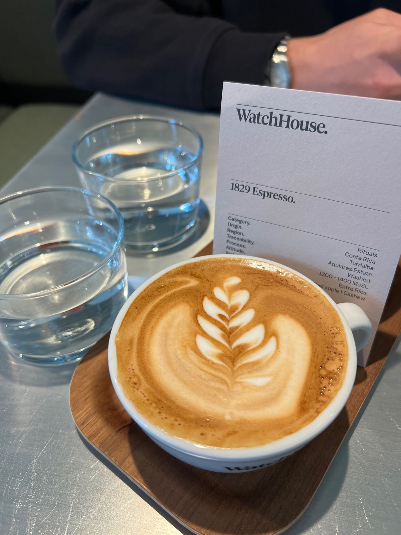 Flat white with latte art next to the 1829 Espresso tasting card