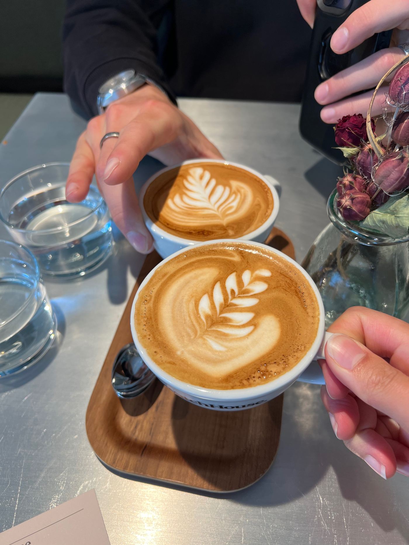 Two flat whites being served at the table